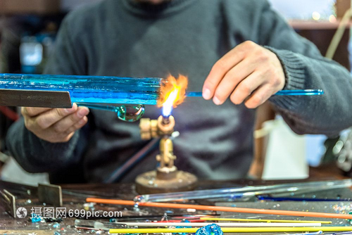 手工艺人用品的在集市上制作玻璃标本Glass制造商用燃烧的火炬制成熔化玻璃将喷灯的火焰贴近新玻璃艺术品手工人在品集市上制作玻璃标